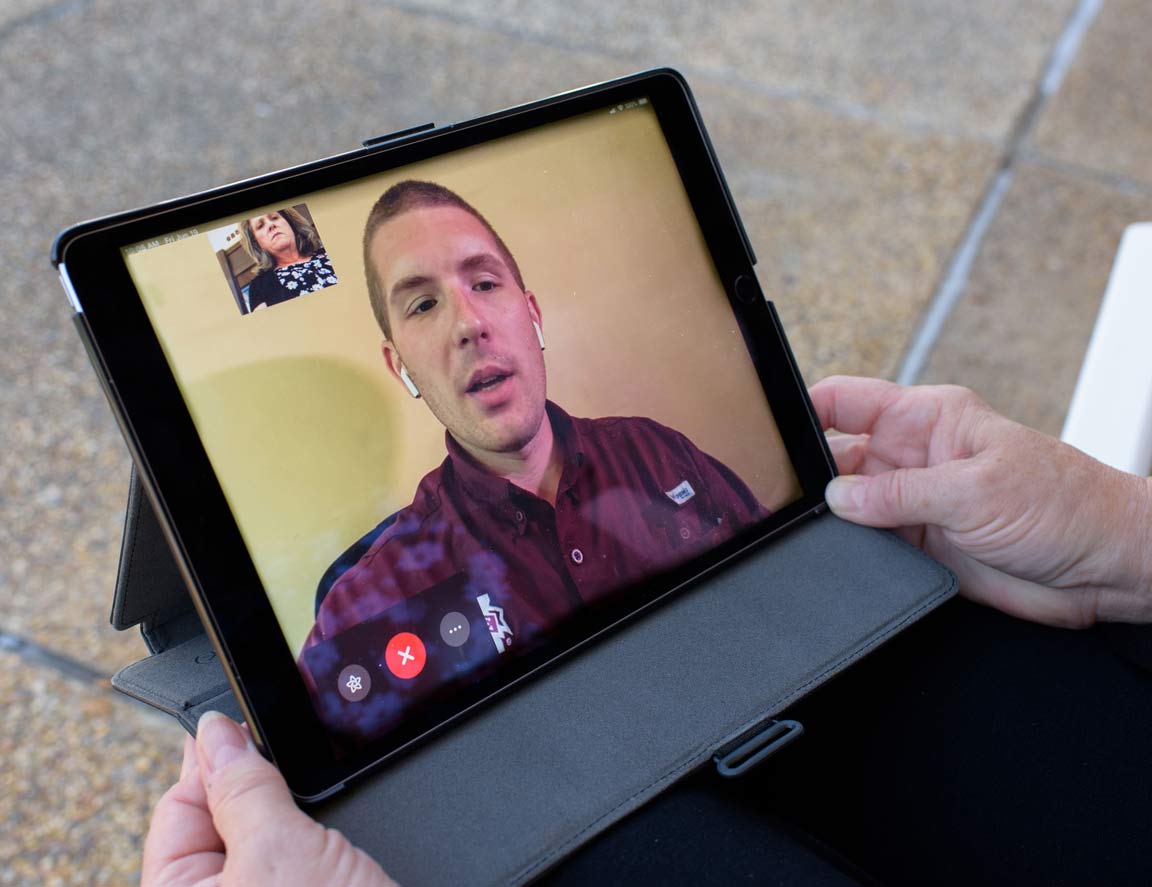 Tablet screen showing a man and woman video chatting. 