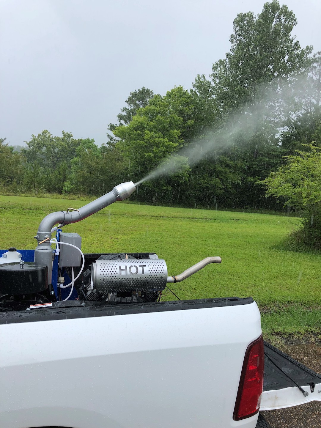 A machine in the back of a truck spraying a mist.