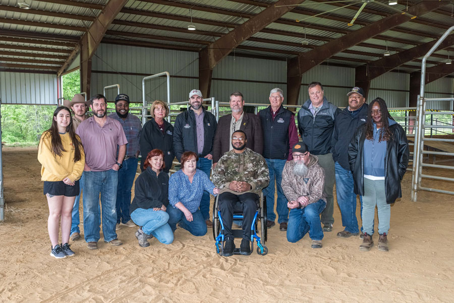 A group of people smiling in a show ring.