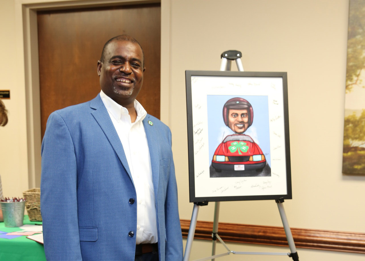 Larry Alexander stands beside a caricature of himself.