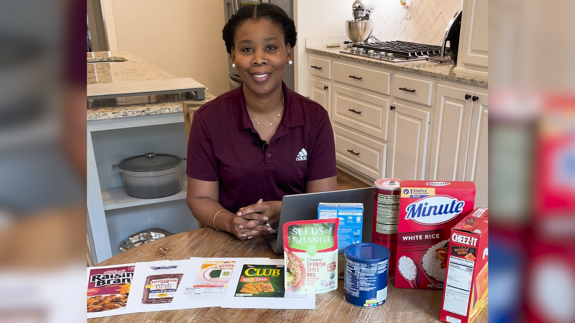 A woman sits at a table with various food products with Nutrition Facts labels displayed.
