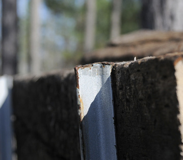 Closeup of the top edge of the backstop. The tops of the T-posts are level with the tops of the crossties.