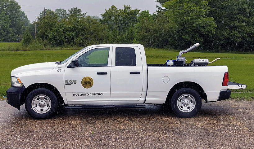 A pickup truck with a mosquito mister in the bed.