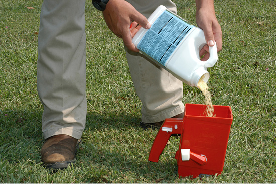 Pouring a treatment into a hand-held spreader.