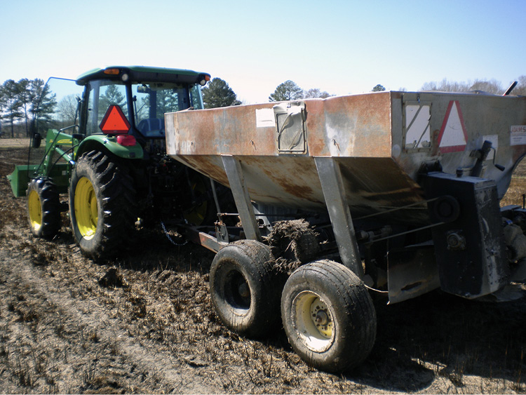 A tractor pulling an implement in a field.