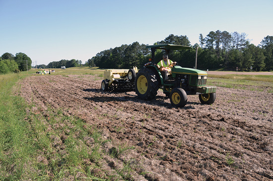 Tractor pulling a no-till drill along a tilled piece of the median. 