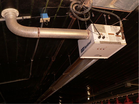 A metal box hanging from the ceiling, with metal tubes exiting on two sides.