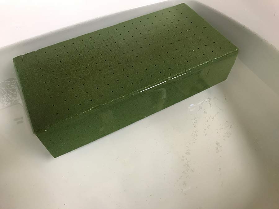 Green floral foam fully absorbed with water.