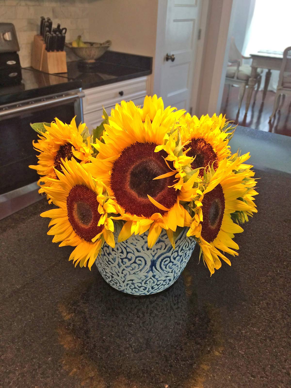 A vase filled with yellow sunflowers.