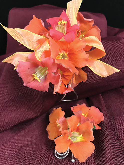 Orange and pink snapdragons made into a corsage with a ribbon and a boutonniere.