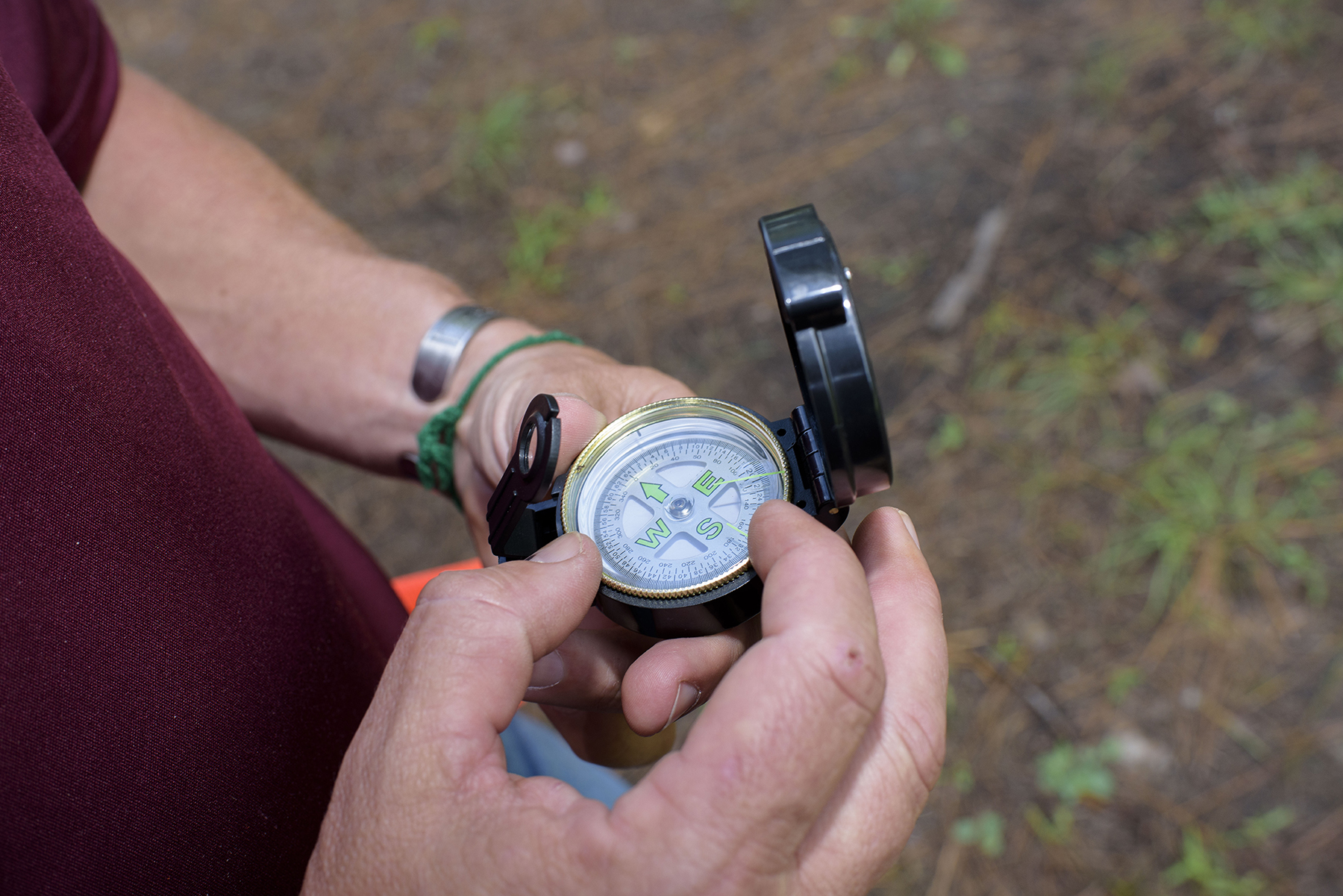 Hands holding open compass, described in the text.