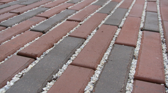 Brick pavers separated by small gravel. 
