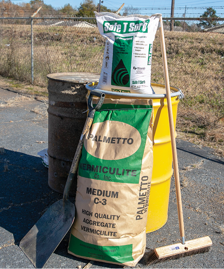 One large bag and one small bag of absorbent material, a large shovel, and a large broom.