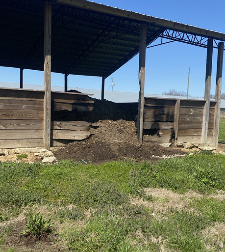 Poultry litter spills from a fire-damaged wood structure.