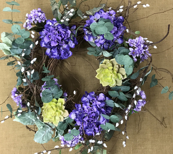 Adding the colors and textures of echeveria and pussy willow to the wreath provide both balance and contrast to the overall design.
