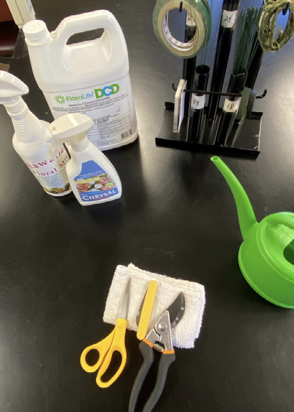 Floral tools and cleaning supplies displayed on a table.