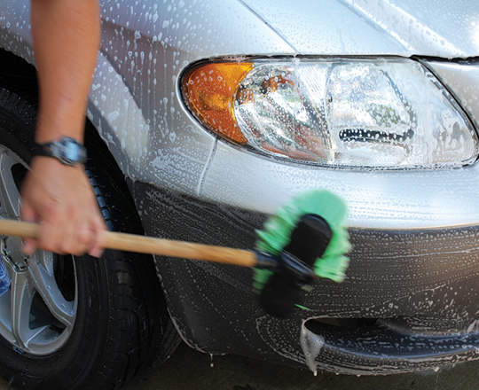 A person washing a vehicle.