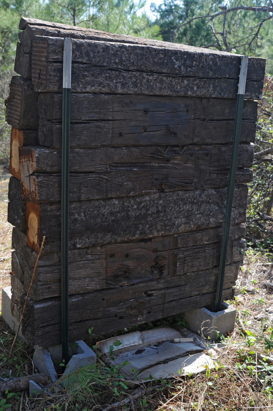 The reverse side of the completed backstop shows the crossties, both T-posts, and two cinder blocks.