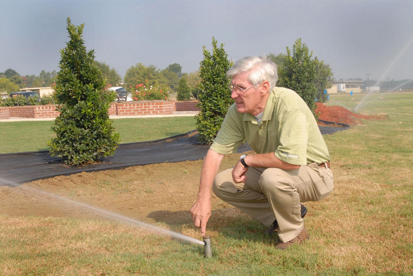 Dr. Wayne Wells adjusts a pop-up irrigation head for best coverage at the R. Rodney Foil Plant Science Research Center at Mississippi State University's North Farm. (Photo by Marco Nicovich)