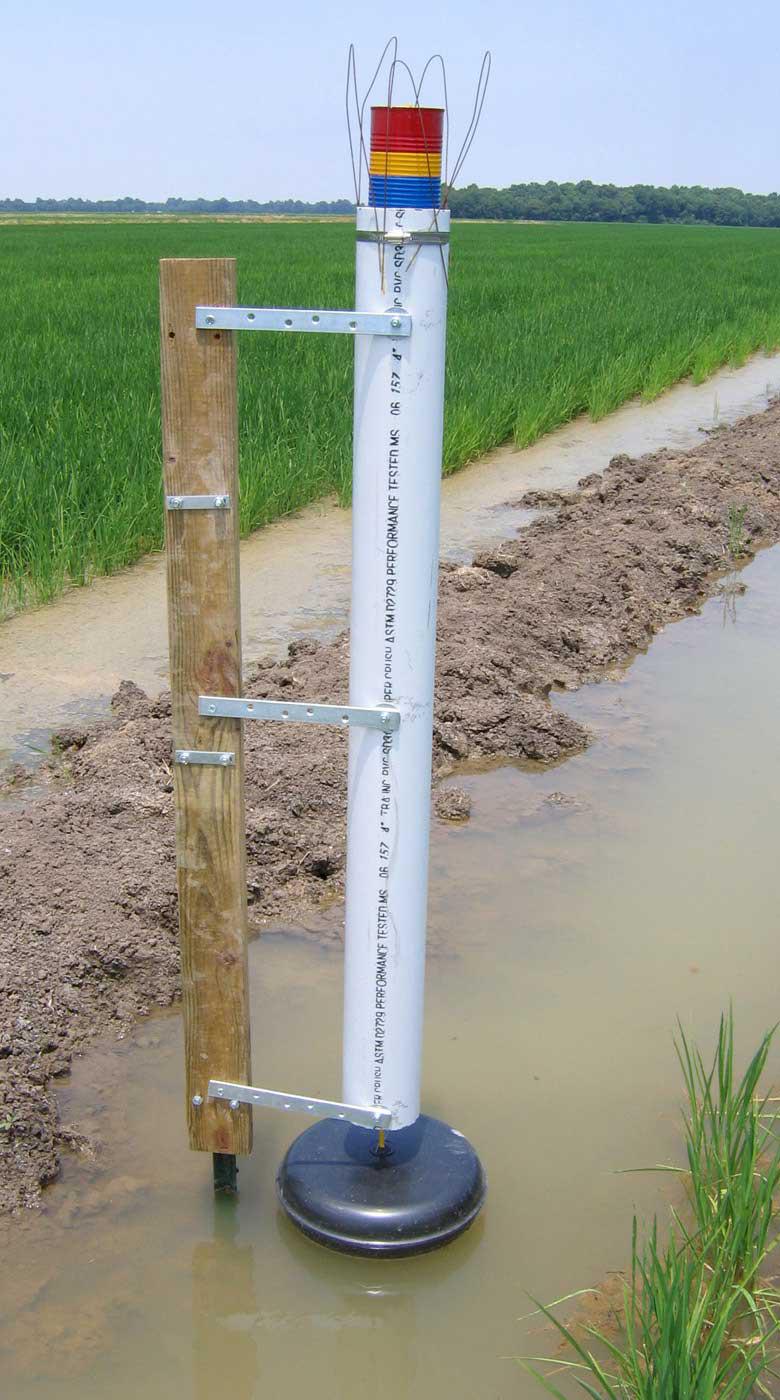 A newly designed flood gauge by Mississippi State University helps rice producers conserve water by allowing them to monitor flood depth from a distance. Red indicates "add water," yellow means "prepare to add water," blue signifies "full flood" and green means "losing money from over-pumping." (Photo by Joe Massey/MSU Department of Plant and Soil Sciences)