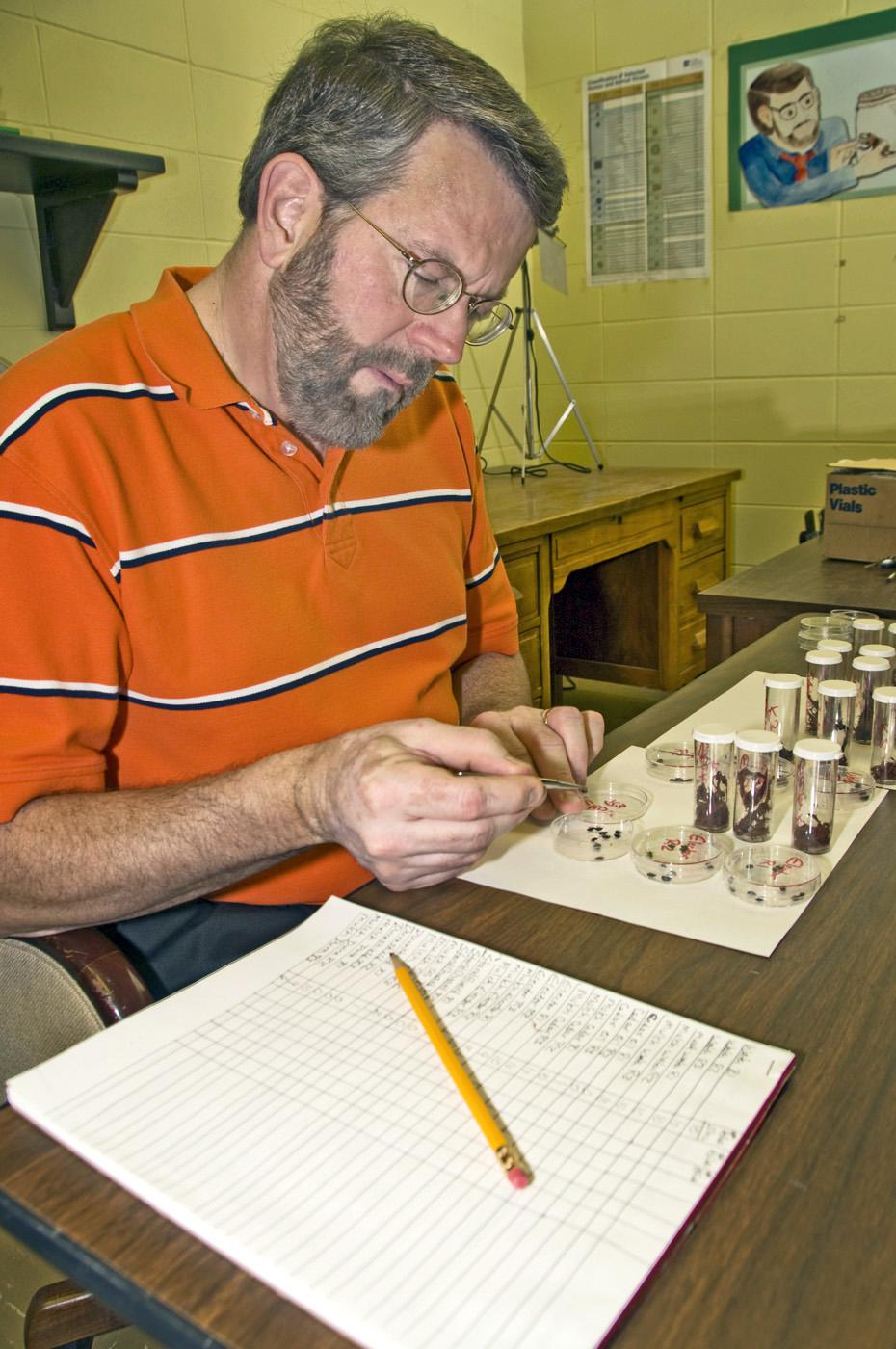 Dr. Jerome Goddard, a medical and veterinary entomologist with the Mississippi State University Extension Service, examines an insect specimen in his laboratory on campus. Goddard hopes to use his experience as a public health entomologist for teaching, research and outreach. (Photo by Marco Nicovich)