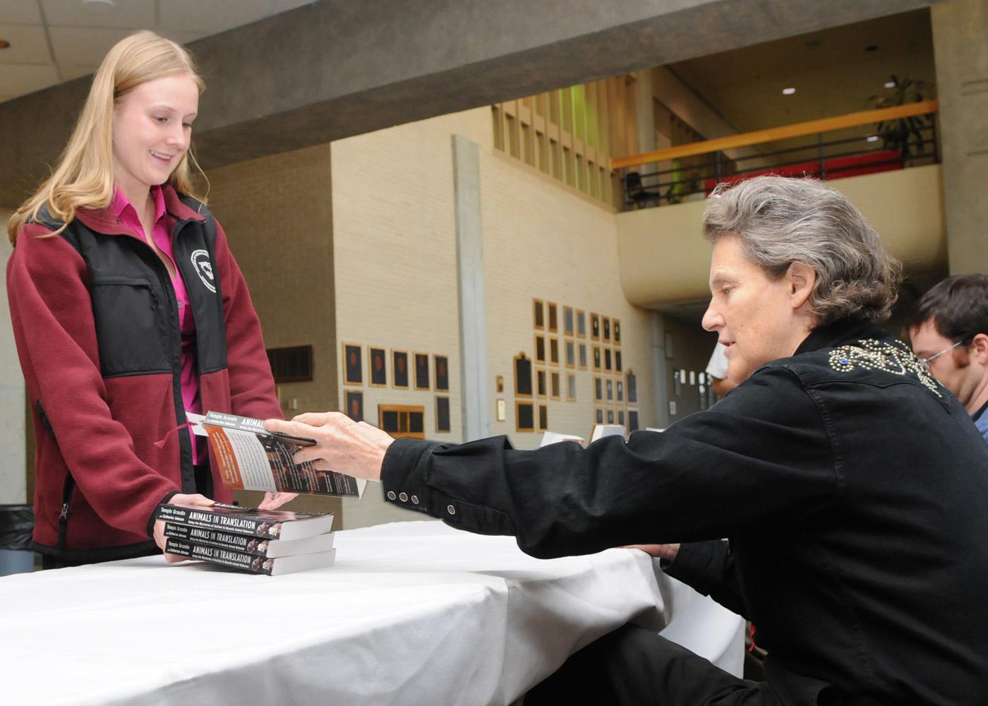Temple Grandin signs a book Tuesday for Mississippi State University student Kristin Nichols, a member of the College of Veterinary Medicine's class of 2010. (Photo by Tom Thompson)