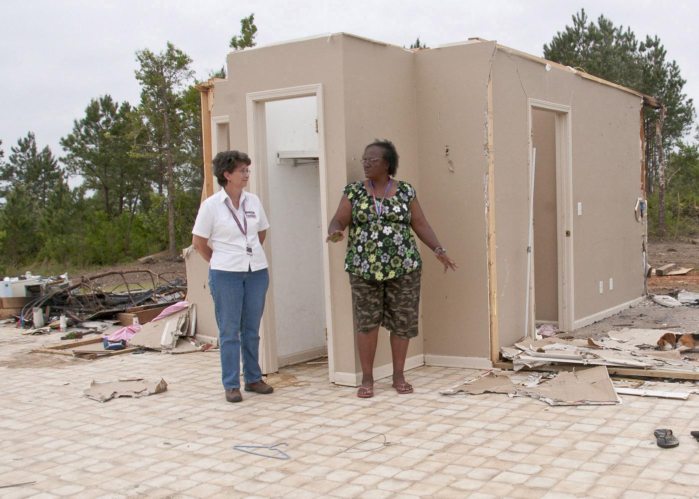 Mae Gladys Dotson, right, shows Choctaw County Extension director Juli Hughes where she sought shelter when the April 24 tornado destroyed her home. (Photo by Scott Corey)