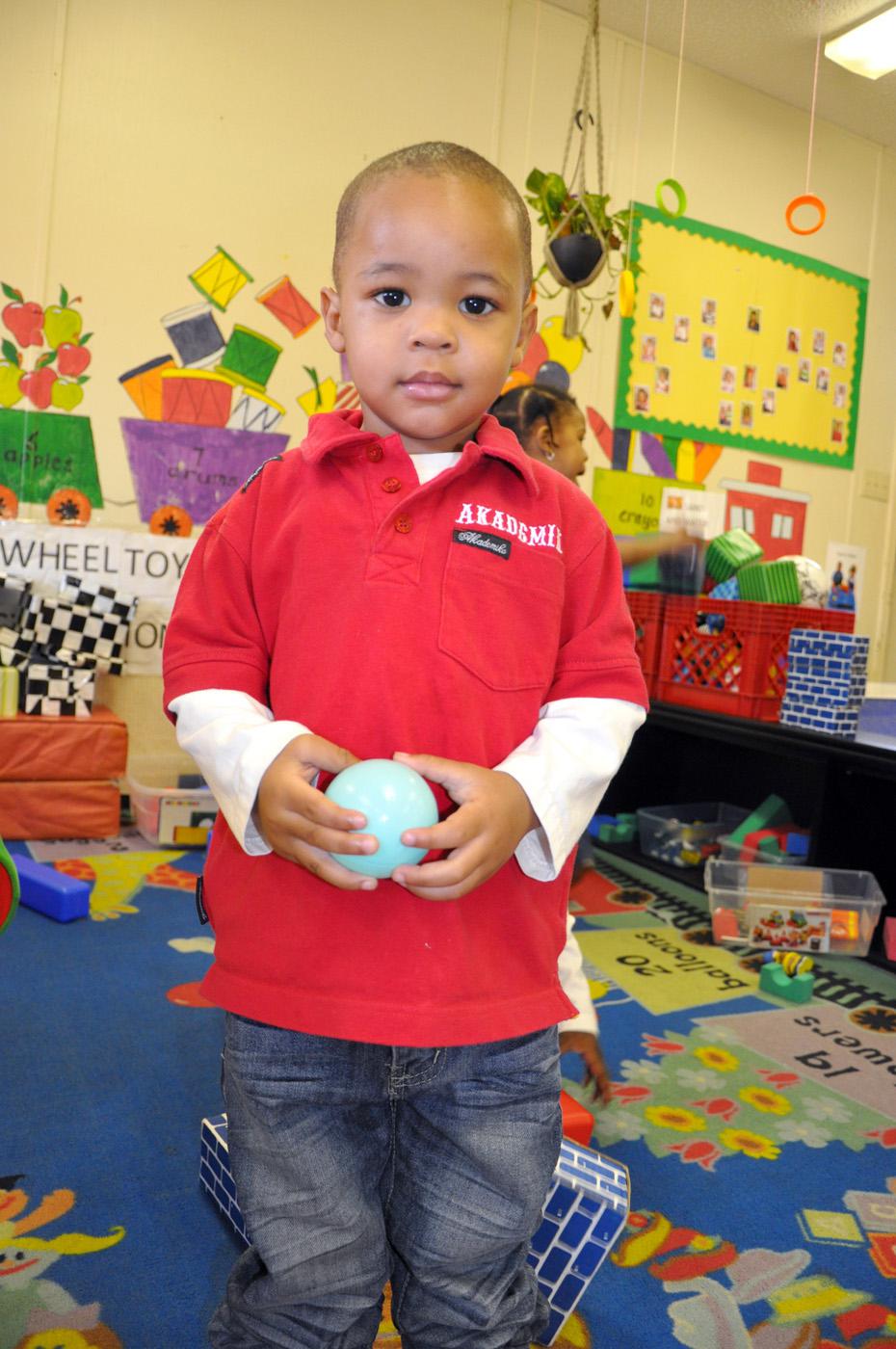 Two-year-old Anquarius Outlaw explores a variety of toys during free-choice center time at the Love & Learn Day Care in Crawford. (Photo by MSU Extension Service/Keri Lewis)