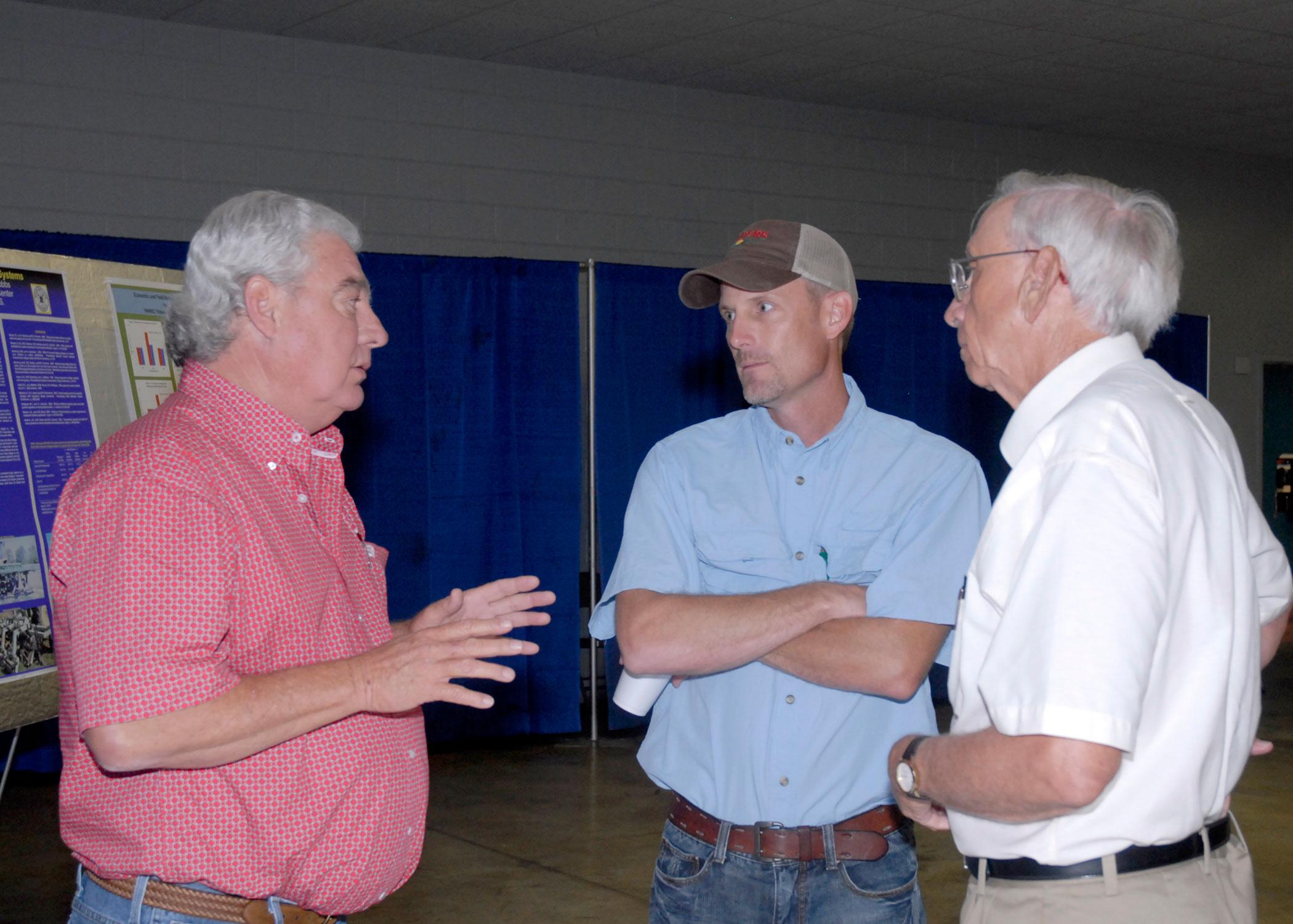 From left, Roger Worsham, a tillage equipment vendor, reviews tillage options with Glenn Gilmer, a farmer from Caledonia, and Normie Buehring, a research professor with the Mississippi Agricultural and Forestry Experiment Station. The three were taking part in the North Mississippi Row Crops Field Day Aug. 9, 2012, at the North Mississippi Research and Extension Center in Verona. (Photo by MSU Ag Communications/Linda Breazeale)