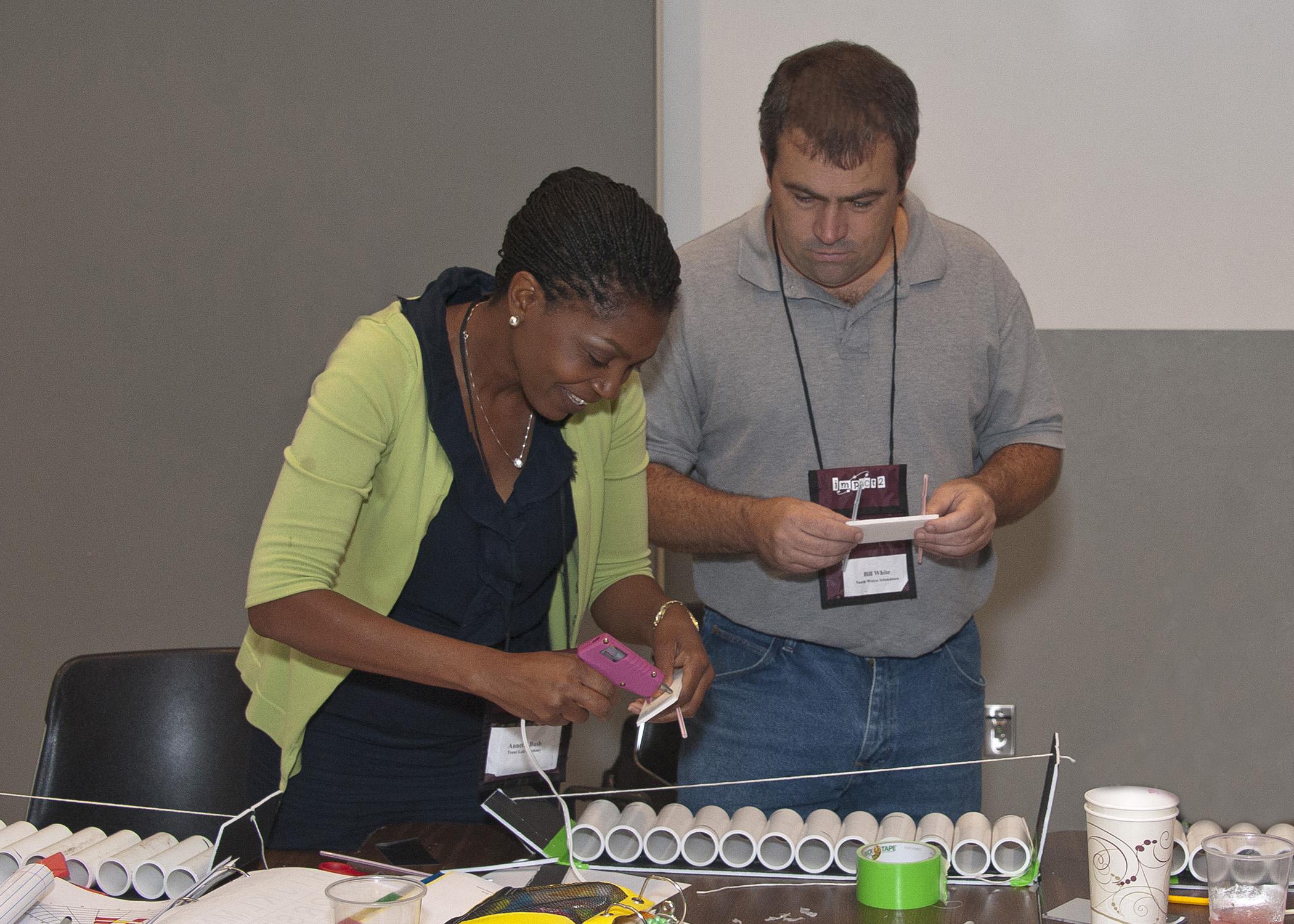 Annette Bush, a fifth-grade teacher at Trent Lott Academy in Pascagoula, discovers the mathematics behind the square-wheeled car by designing one for her classroom on June 24, 2014, during a two-week In-depth Mathematical Practices and Content Teacher Training at Mississippi State University. Bill White, an eighth-grade teacher at Nanih Waiya Attendance Center near Louisville, was one of five mentor teachers for IMPACT2. (Photo by MSU Ag Communications/Kevin Hudson)