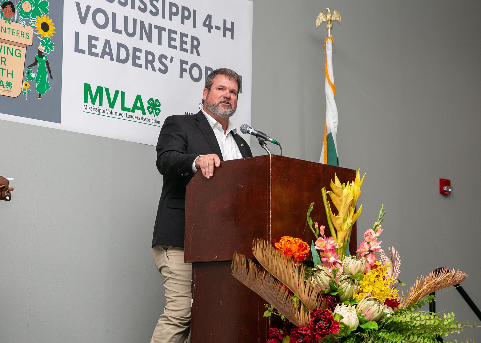 A man standing at a podium with a microphone.