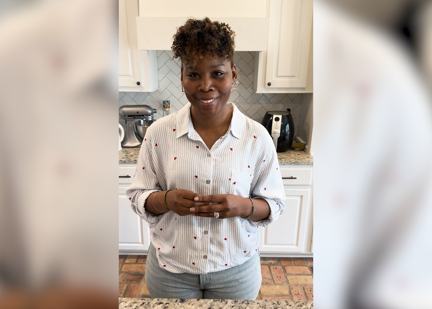 A woman stands in a kitchen.