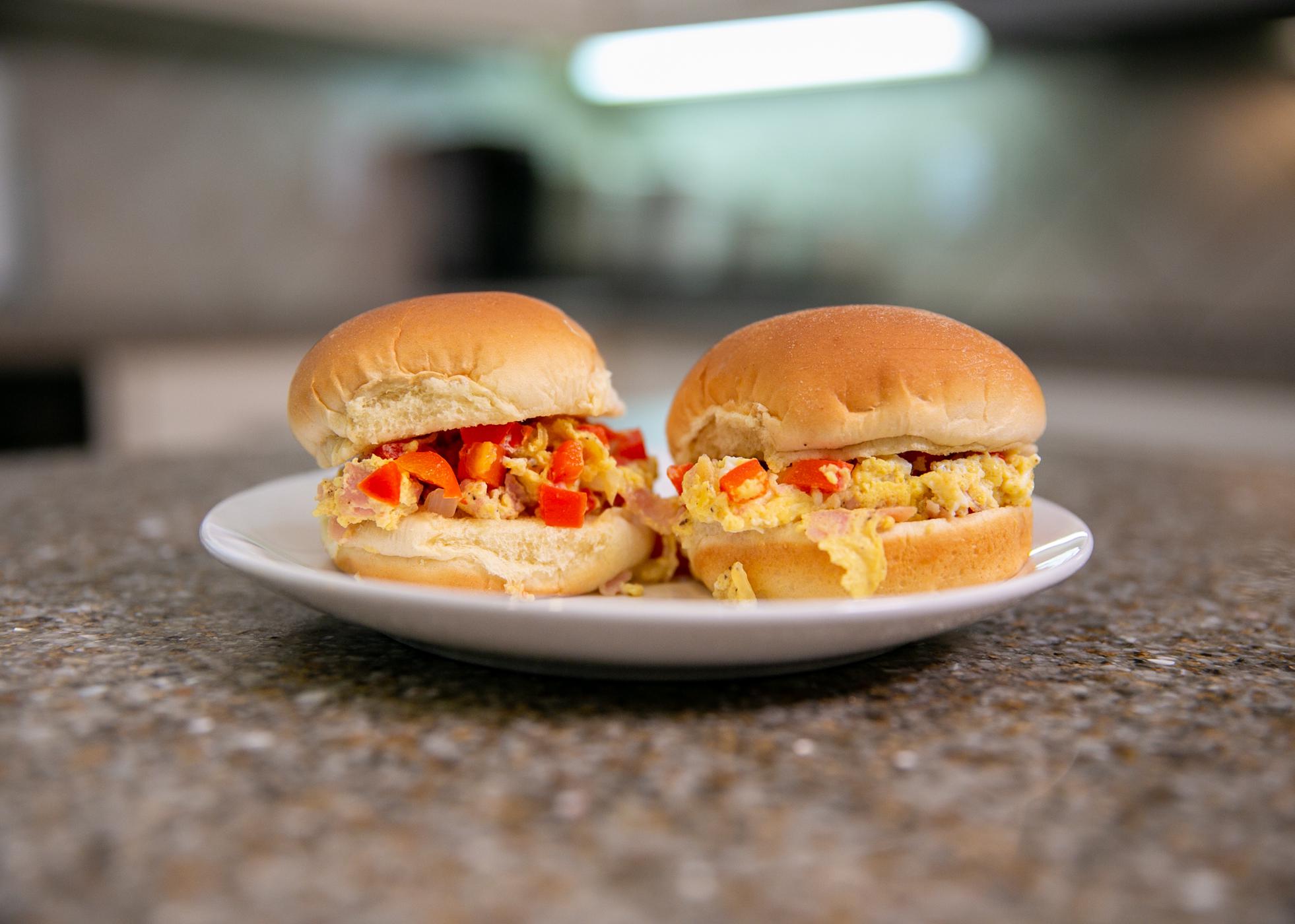 Two Microwave Denver Scramble Sliders sit on a plate on a kitchen countertop.
