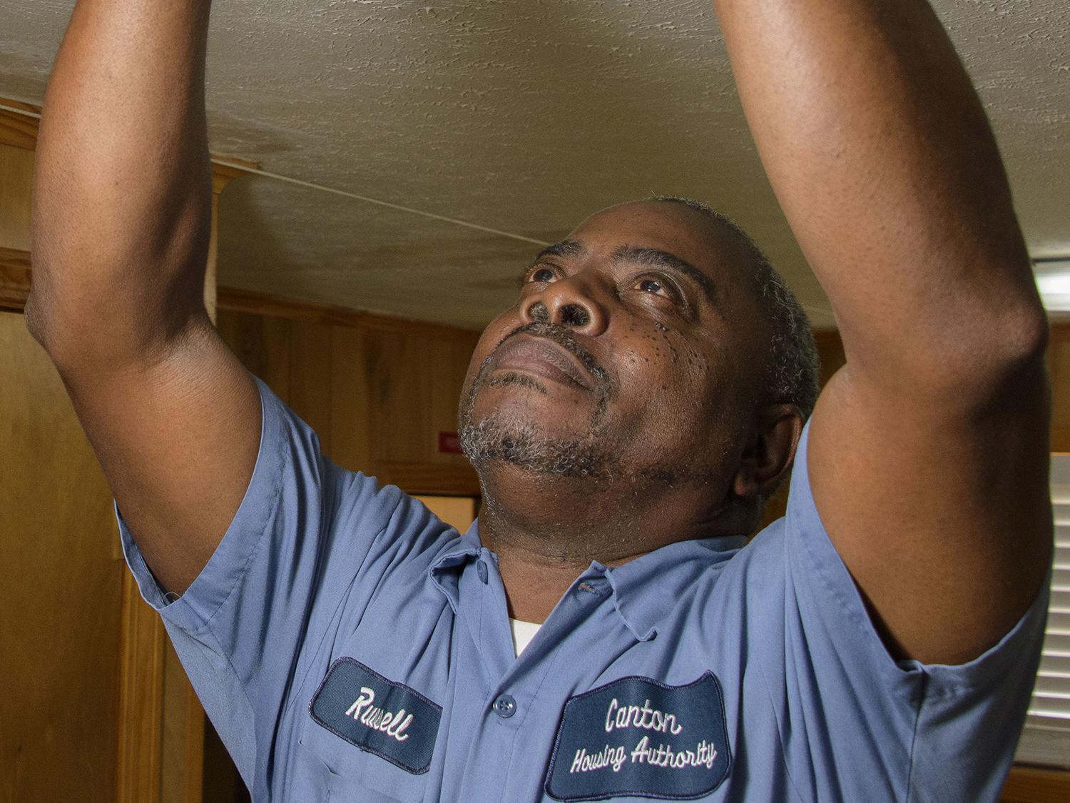 Russell Carroll, a maintenance supervisor with the Canton Housing Authority in Canton, Mississippi, checks batteries in a smoke detector in one of the housing units he services. Carroll participated in a Healthy Homes Initiative training and shares information with his colleagues and clients to help them improve their environments. (File photo by MSU Extension Service/Kevin Hudson)