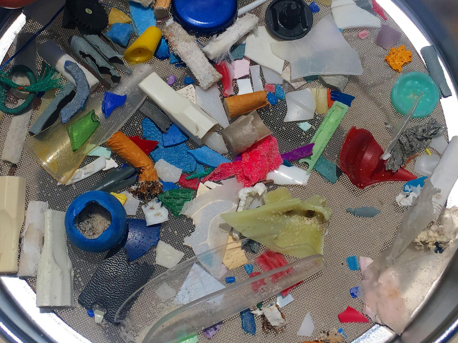 Looking down on a round pan with various small pieces of plastic.