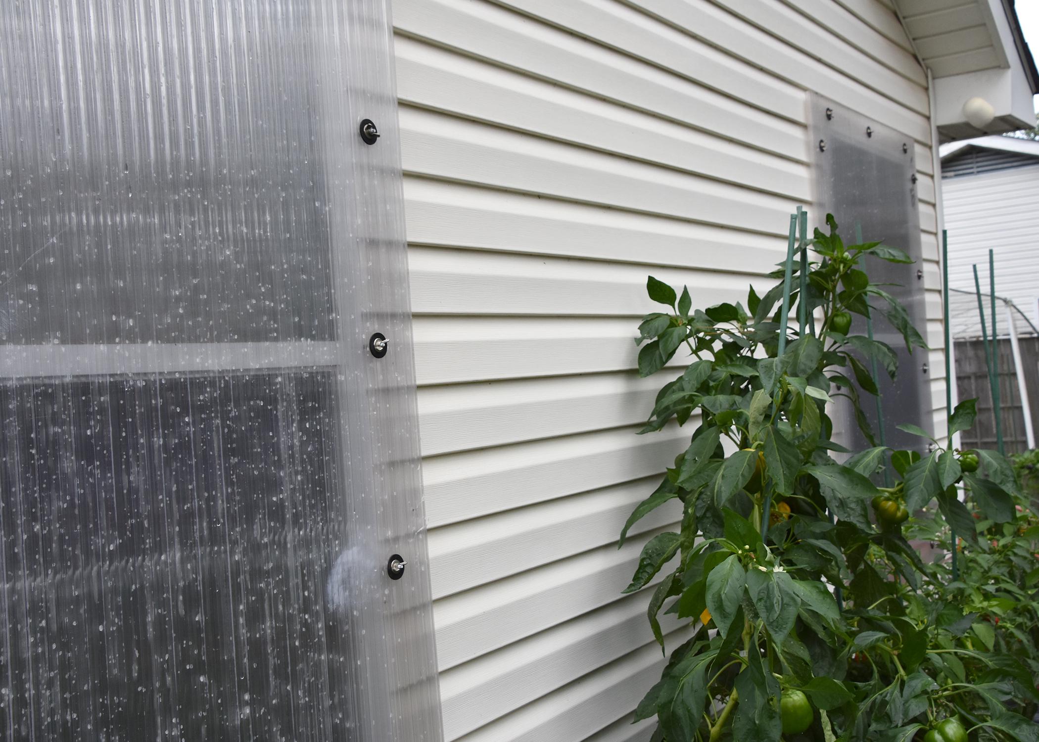 A clear panel covers a window on the exterior of a house.