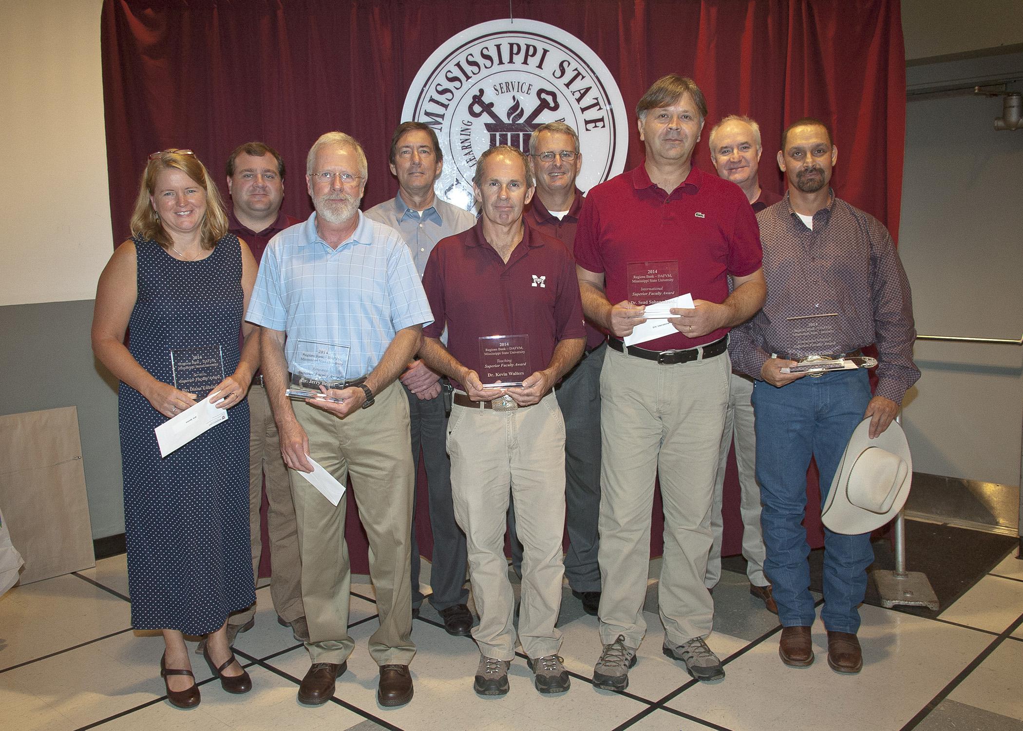 Regions Bank representatives joined Mississippi State University Division of Agriculture, Forestry and Veterinary Medicine administrators and faculty to recognize the winners of the 2014 Regions Bank-DAFVM, MSU Superior Faculty Awards on July 25, 2014. Back row, from left: Walt Stephens, Regions Greenville City president; Gregory Bohach, DAFVM vice president; Samuel W. Slaughter III, Regions Starkville City president; and George Jarman, Regions Delta City president. Front row, from left: Service Award winne