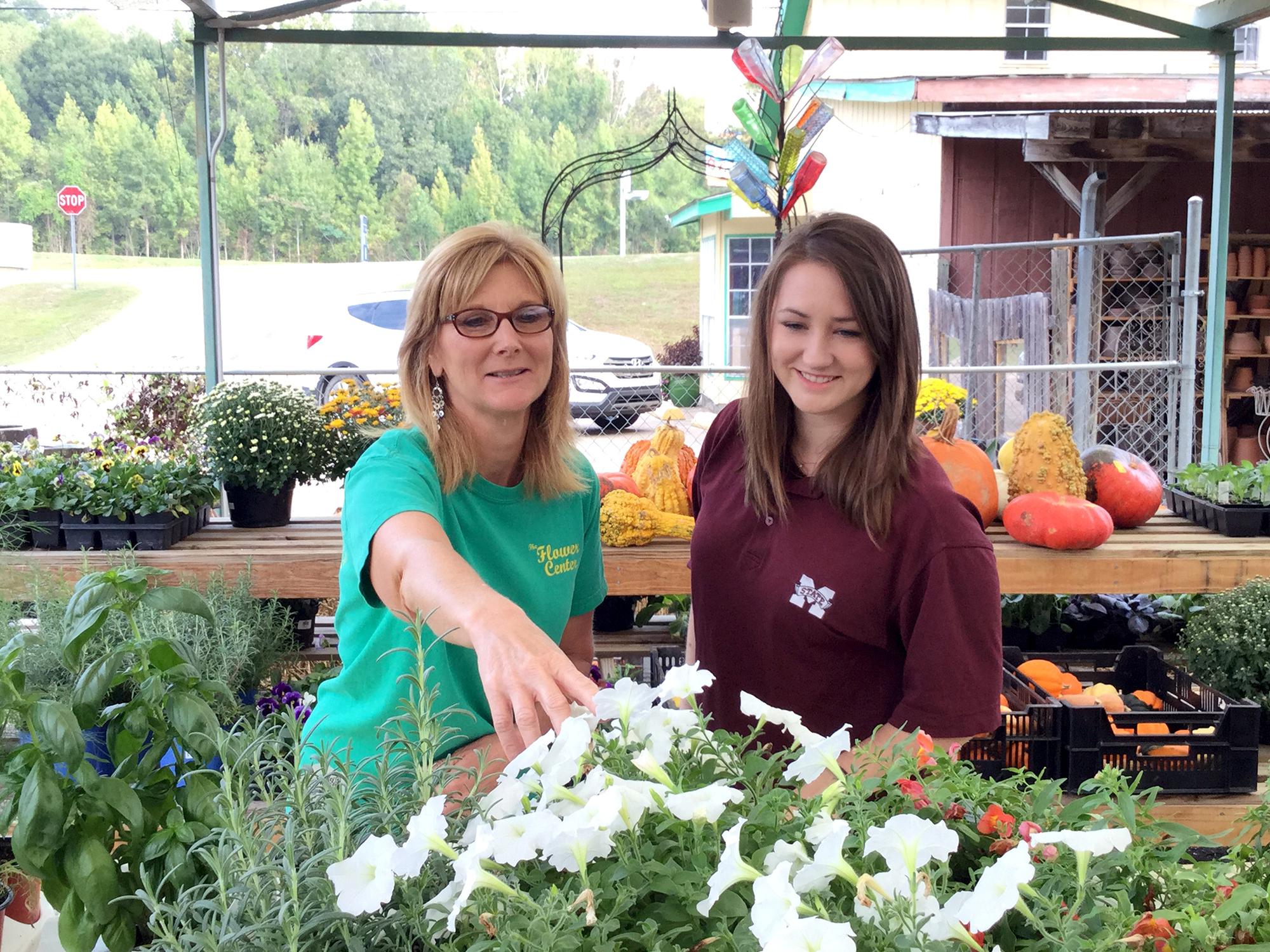 Libby Beard, co-owner of The Flower Center in Vicksburg, Mississippi, left, and Anna McCain, Warren County Extension agent, look over some of the fall bedding flowers available on Oct. 7, 2015. (Submitted photo)