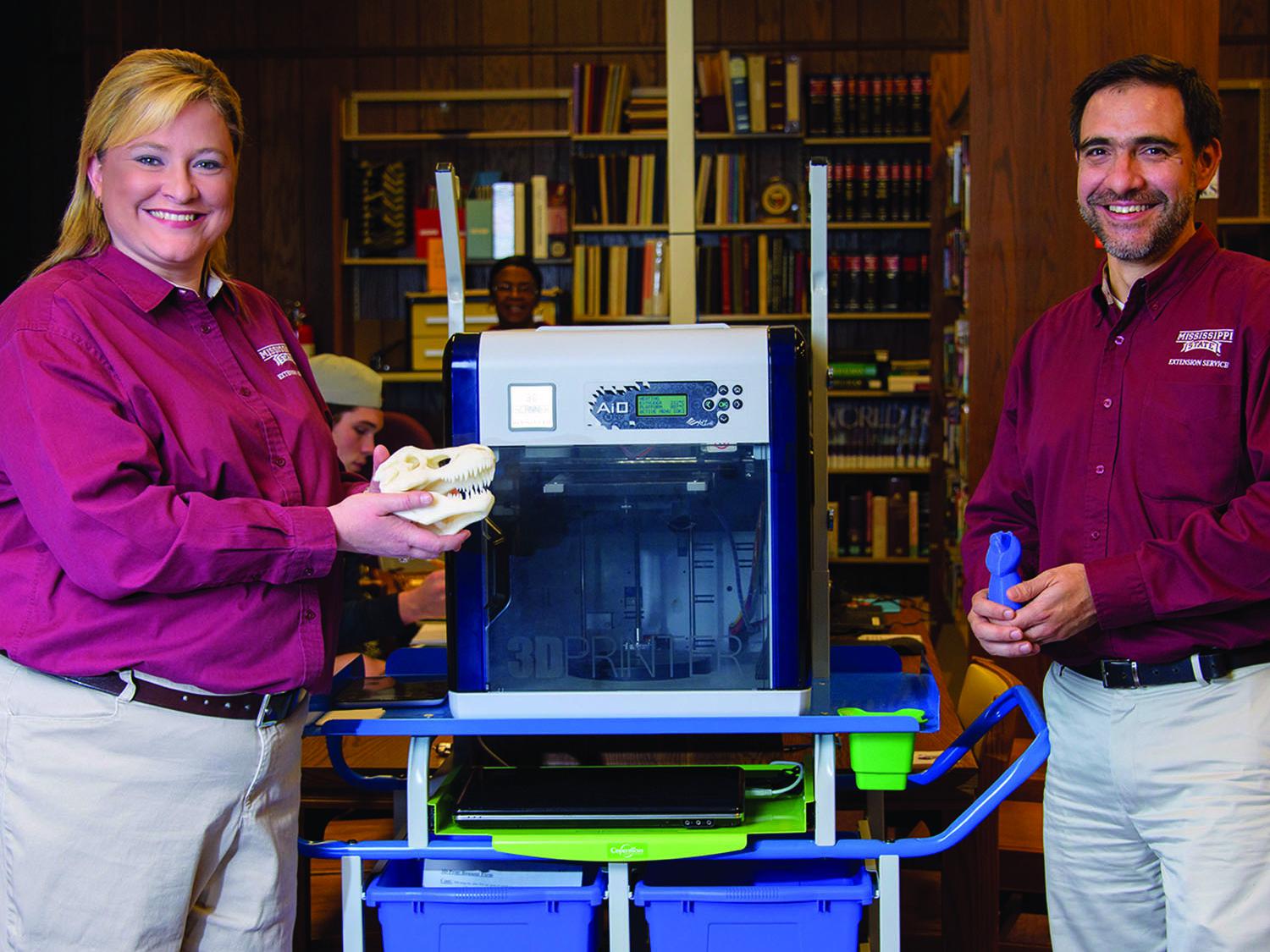 Christy King, Clarke County Extension agent, and Roberto Gallardo, an associate Extension professor in the Center for Technology Outreach, display items made with a new 3-D printer at the Quitman Public Library. (Photo by MSU Extension Service/Kevin Hudson)