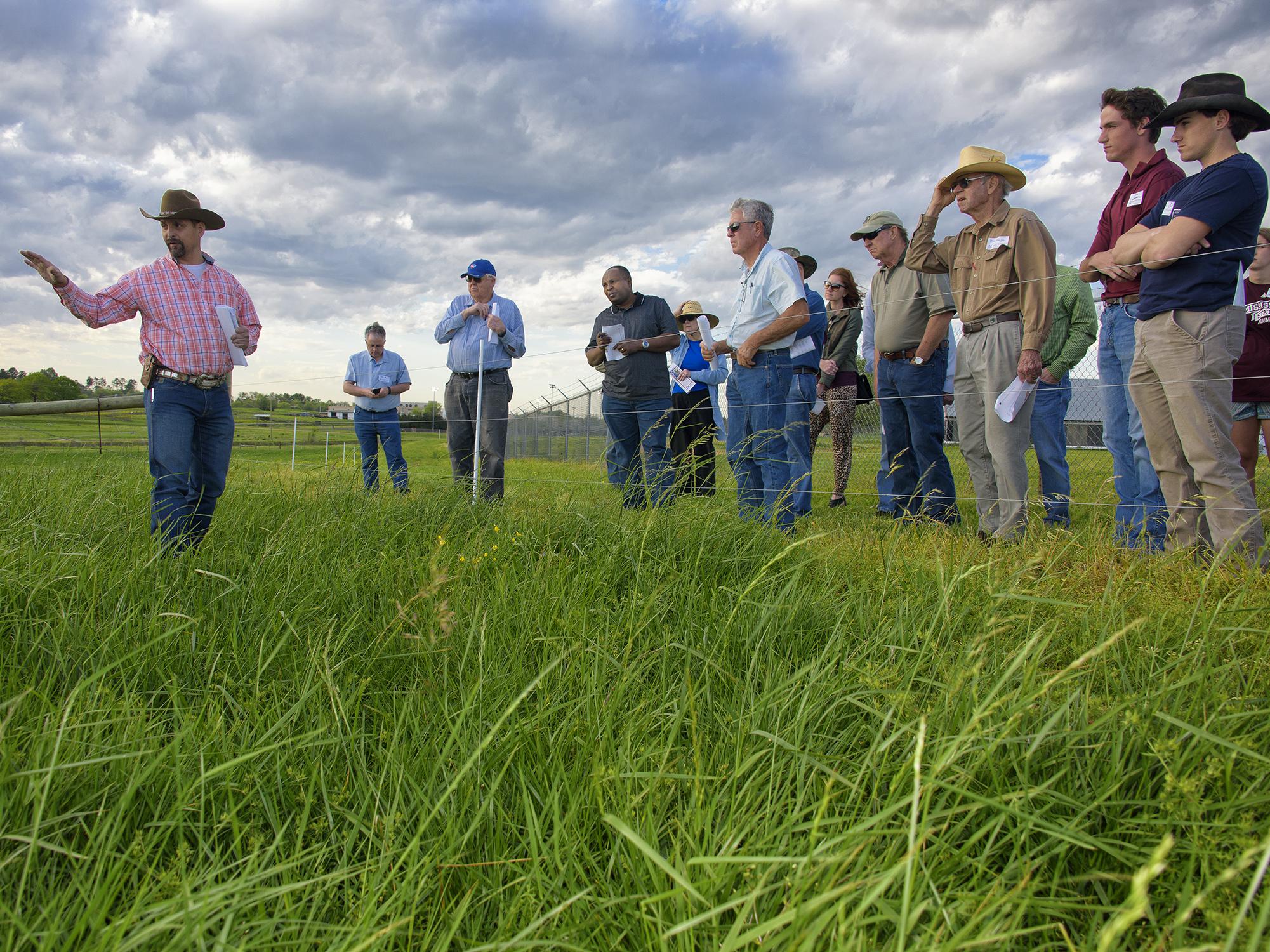 Rocky Lemus (left), forage specialist with the Mississippi State University Extension Service, explains successes and challenges with fescue growing at the H.H. Leveck Animal Research Center. Lemus led tours during a Forage Field Day near Starkville, Mississippi, on April 7, 2016. (Photo by MSU Extension Service/Kevin Hudson)