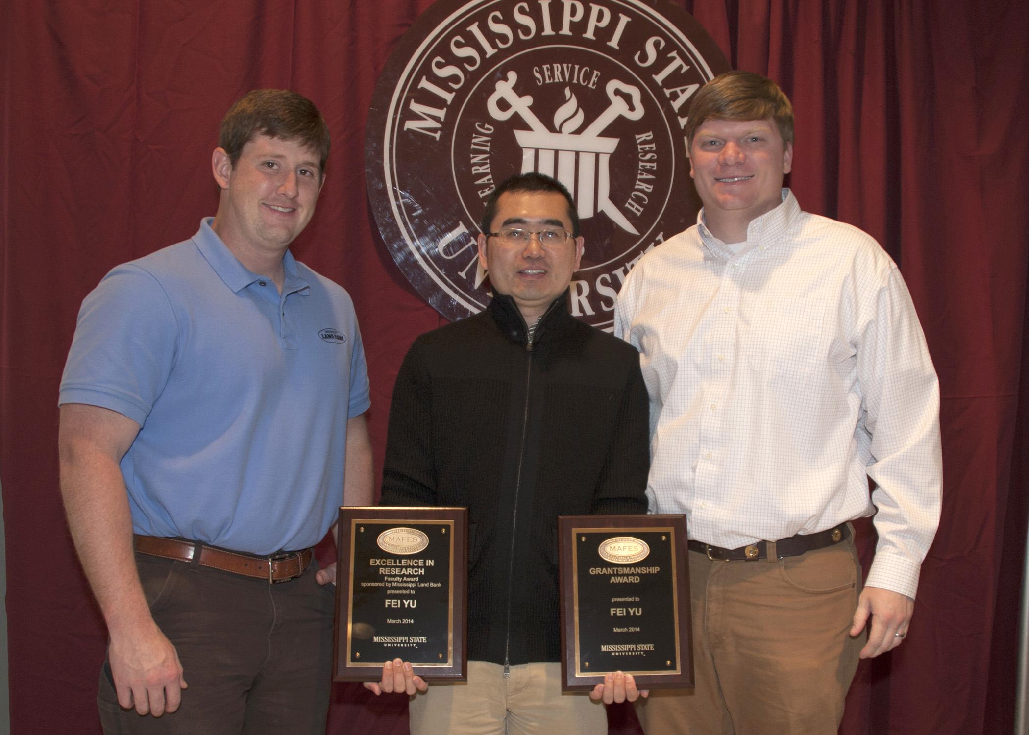The Mississippi Agricultural and Forestry Experiment Station recently honored Mississippi State University scientists and students for outstanding research. Fei Yu, center, received the 2014 Excellence in Research Award. Tyler Anderson, left, and Bart Harris represent Mississippi Land Bank, which sponsored the award. (Photo by MSU Ag Communications/Kat Lawrence) 