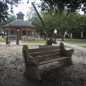 A bench in front of a brick pavilion.