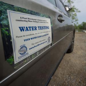 A truck with a sign listing “Water Testing: Keeping Your Water Clean and Healthy!”