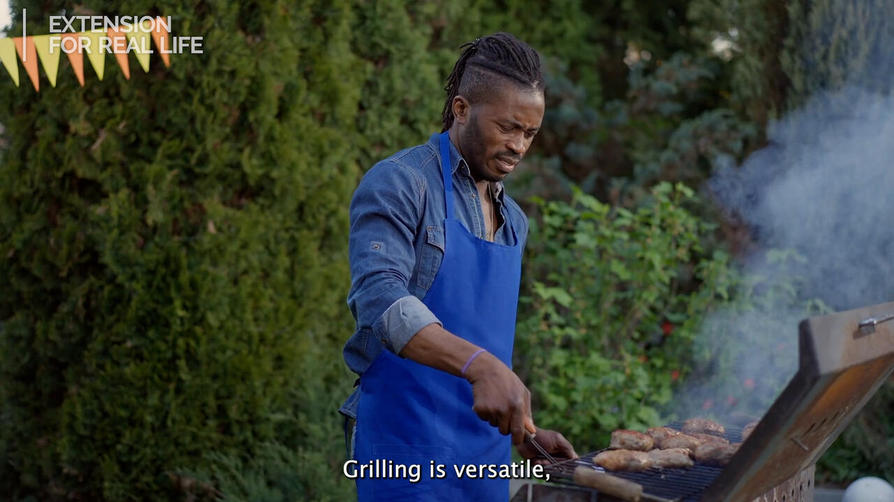 A man cooks food on a grill.
