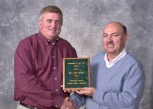Mississippi State University Extension Service soybean specialist Alan Blaine, left, was presented with the Mississippi Society of        			Agronomy's Agronomist of the Year award by the organization's president David Roberts.