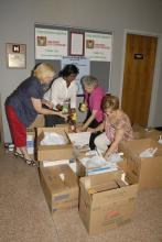 Mississippi Extension office associates Joyce Thompson of Oktibbeha County, Barbara Curry of the Northeast District office, Mary Minor of Marshall County and Colleen Butler of Scott County sort through hundreds of food items collected during their 2009 state meeting. (Photo by Linda Breazeale)