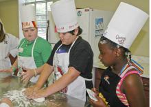 Lamar Land, Ben Barker and Murritta Lane work as a team kneading dough to make bread at the annual "Fun with Food Camp." Land, Barker and Lane attended the camp in 2009 and had the opportunity to make many nutritious meals and learn more about the culinary arts. (Photo by Karen Templeton)