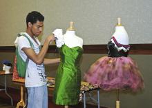 MSU freshman Jay Grishby of Jackson puts the finishing touches on his haute couture cocktail dress that was featured in a recent campus fashion exhibit.