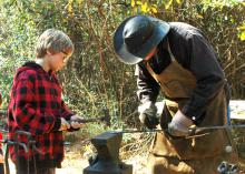 Fourth-generation blacksmith Chuck Averett helps Morgan Alexander make an arrowhead at the Piney Woods Heritage Festival held Nov. 16 and 17 at Mississippi State University's Crosby Arboretum. (MSU Ag Communications/Susan Collins-Smith)