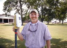 Jason Krutz, irrigation specialist with Mississippi State University's Delta Research and Extension Center, says he believes that soil moisture sensors can save farmers money, conserve water and extend the life of irrigation pumps. Krutz is holding one of the sensors during the Corn and Soybean Field Day in Stoneville, Miss., on July 18, 2013. (Photo by MSU Ag Communications/Linda Breazeale)